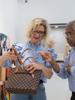 Senior couple browsing handbags in a stylish retail store in Portugal.